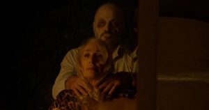 Two people stare into a mirror.