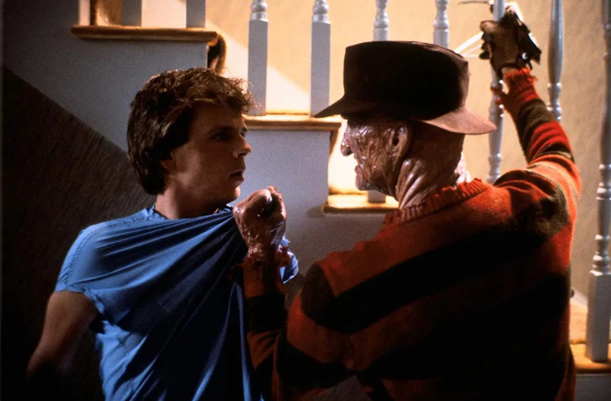 Freddy Kruguer grabs Jesse and raises his razored glove in A Nightmare on Elm Street 2