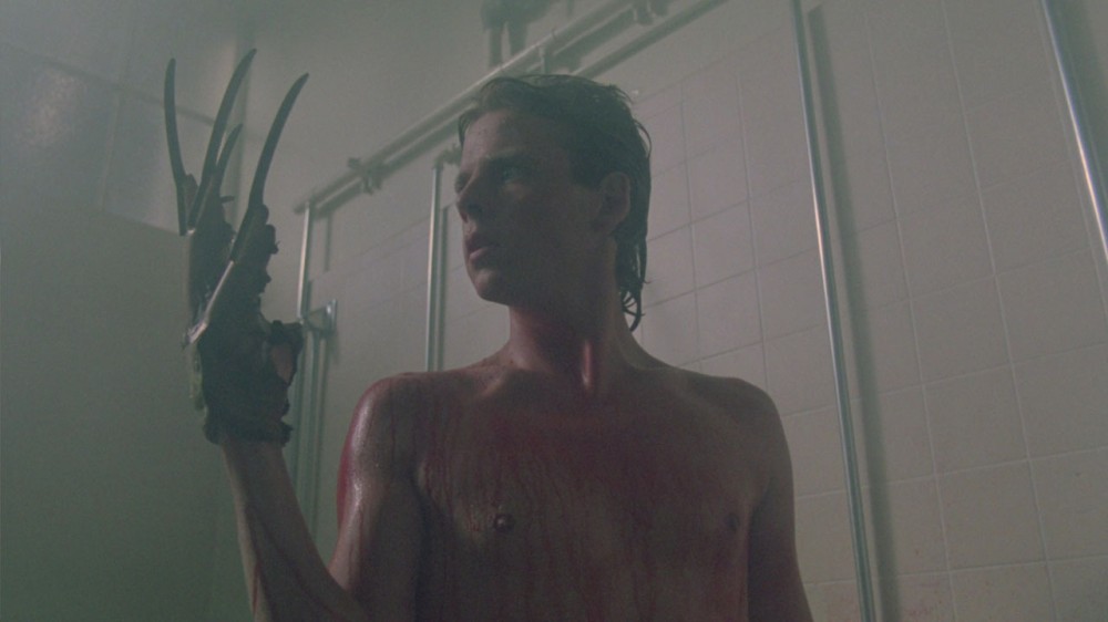 Jesse stares at his hand wearing Freddy's glove while he stands in the shower